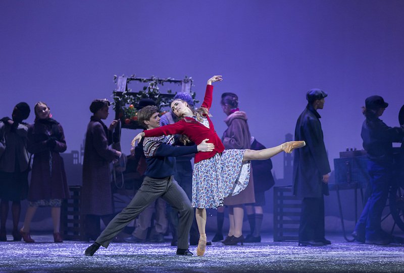 A couple into winter clothing dances together at an outdoor market